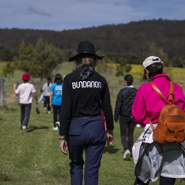 People walking in a paddock.
