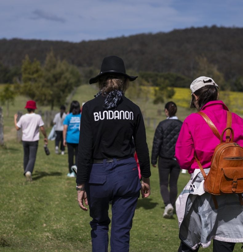 People walking in a paddock.