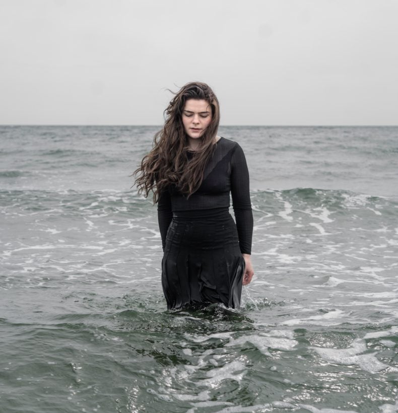 Woman in black in ocean water